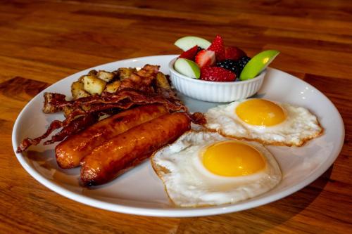 een bord ontbijtproducten met eieren, spek en fruit bij Holiday Inn Laval Montreal, an IHG Hotel in Laval