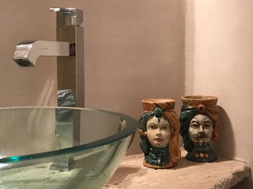 a bathroom sink with a glass bowl with a head on it at Domus '400 in Pisa