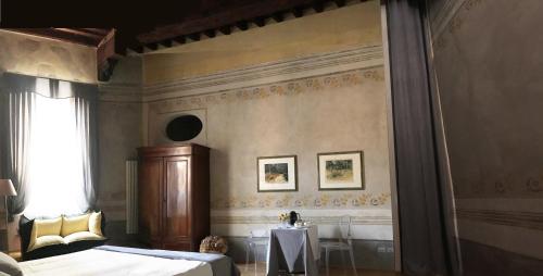 a bedroom with two beds and a table and a window at Domus '400 in Pisa