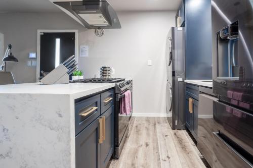 a kitchen with blue cabinets and a refrigerator at Fam Friendly 2BD 8min from airport, 4min from SoFi in Los Angeles