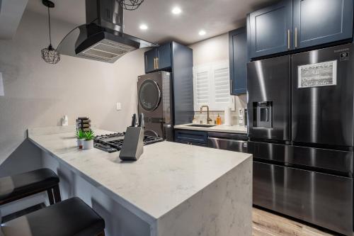 a kitchen with blue cabinets and a stainless steel refrigerator at Fam Friendly 2BD 8min from airport, 4min from SoFi in Los Angeles