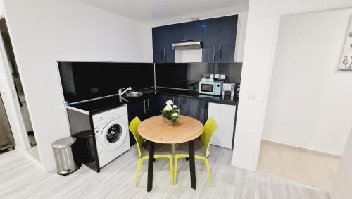 une petite cuisine avec une table et un micro-ondes dans l'établissement Appartement lumineux avec parking, à Sevran