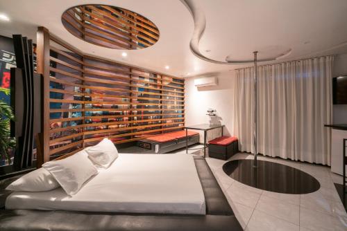 um quarto com uma grande cama branca e uma mesa em Taikô Motel by Drops em Porto Alegre