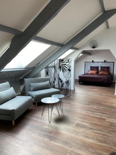 a attic room with a couch and a bed at Villa Manoca in Boisemont