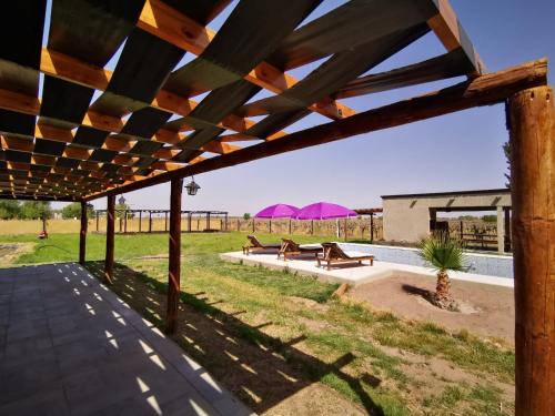 eine Terrasse mit Picknicktischen und rosa Sonnenschirmen in der Unterkunft Casa Quinta la costa in Alto Verde