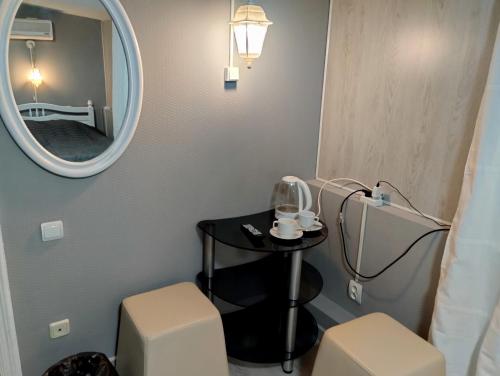 a bathroom with a mirror and a table and two stools at Rest Home Hotel in Nizhny Novgorod