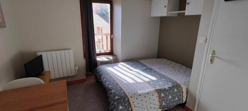 een kleine slaapkamer met een bed en een raam bij Studio-centre-Thabor-calme in Rennes