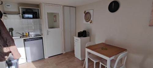 een kleine keuken met een tafel en een kleine tafel en stoelen bij Studio-centre-Thabor-calme in Rennes