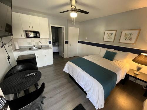 a bedroom with a bed and a desk and a kitchen at Celadon Lodge in Radium Hot Springs