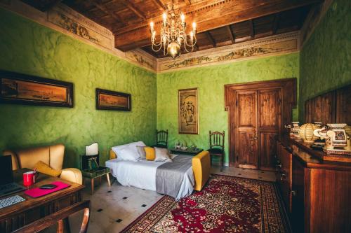 a bedroom with green walls and a bed and a chandelier at ART DÉCO 1920 Vicino AUTOSTRADA 40 MIN ROMA in Orte