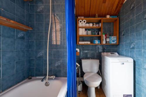 a bathroom with a toilet and a bath tub at La Belette - Duplex au charme savoyard avec vue sur la montagne in Les Allues