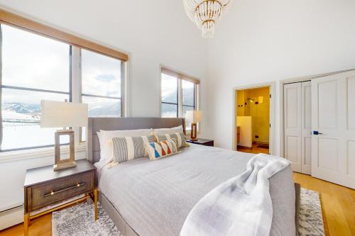a white bedroom with a large bed and windows at Chapel Square Condo in Avon