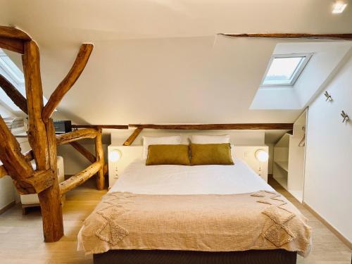 1 dormitorio con 1 cama grande en el ático en La Bel échappée, en Aubel