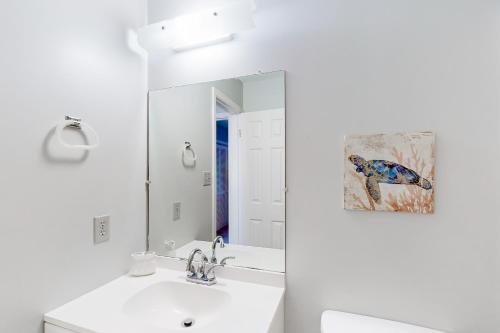 La salle de bains blanche est pourvue d'un lavabo et d'un miroir. dans l'établissement Ramsgate Harbor 26, à Panama City Beach