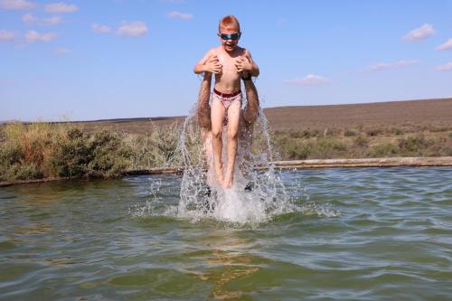 a man jumping into a body of water at Oupoort Eco & Guest Farm - Sutherland - Middelpos in Sutherland