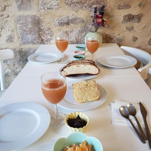 une table avec des assiettes de nourriture et des verres de vin dans l'établissement Chambres d'hôtes au centre de Guémené-sur-Scorff, à Guéméné-sur-Scorff