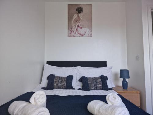 1 dormitorio con 1 cama con 2 sillas blancas en The Commuter's Lodge, en Laindon