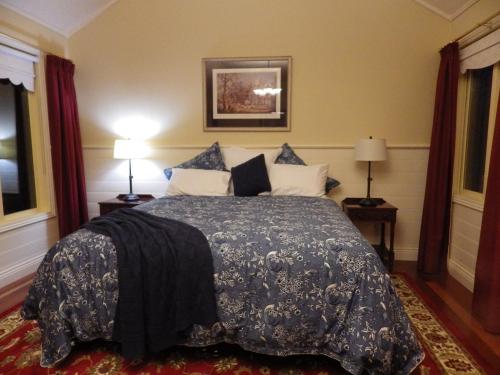 a bedroom with a bed with a blue comforter at The Retreat at Amryhouse in Ashbourne