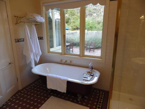 baño con bañera y ventana en The Retreat at Amryhouse en Ashbourne