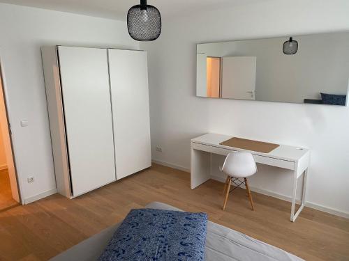 a bedroom with a white desk and a mirror at Schöne Wohnung in der Nähe von München in Germering