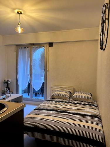 - une chambre avec un lit, une fenêtre et un lavabo dans l'établissement Joli studio avec parking privé, à Moulins