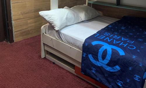 a bed with a blue comforter and a pillow at HPLagos in Lagos