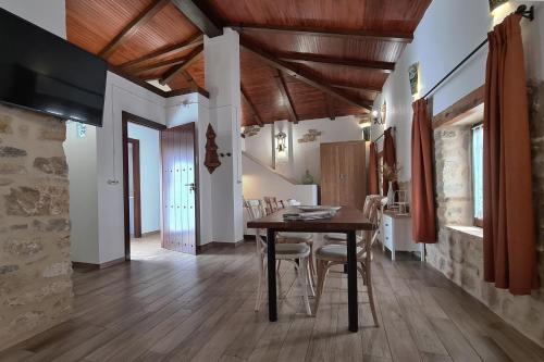 ein Esszimmer mit einem Holztisch und Stühlen in der Unterkunft Apartamentos Turísticos El AOVE in Baeza