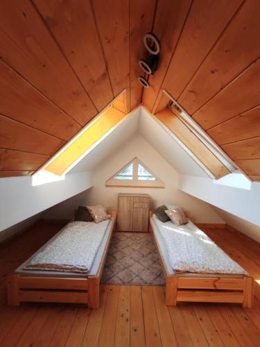 two beds in a room with a roof at Dom Na Brzoskwiniowej in Ustroń
