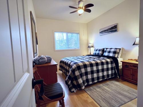 a bedroom with a bed and a ceiling fan at The Wonderland Cottage in Haliburton