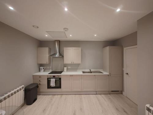 a kitchen with white cabinets and a stove top oven at Central Huddersfield Apartment in Huddersfield