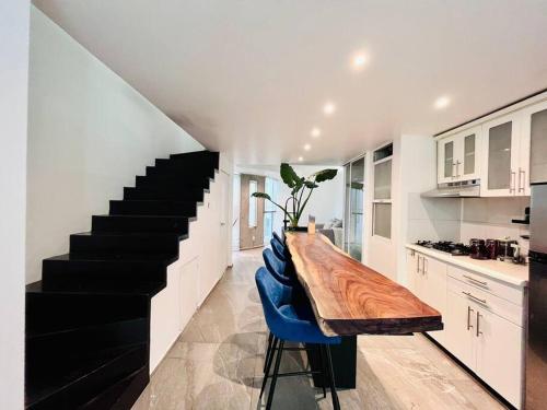 una cocina con una mesa de madera y una escalera en Loft de estilo, moderno, amplio y súper cómodo., en Ciudad de México