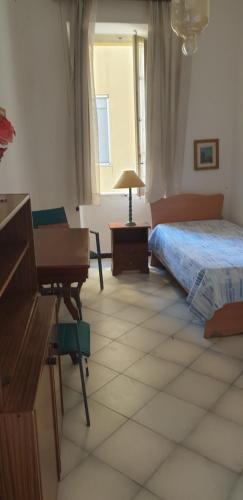 a bedroom with a bed and a desk and a piano at Casa vacanze Cagliari, in Cagliari