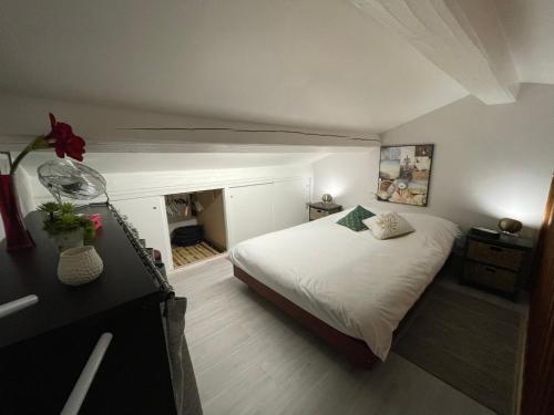 - une chambre avec un lit blanc et une cheminée dans l'établissement sainte maxime FRANCE 4 étoiles front de mer plage de la Nartelle, à Sainte-Maxime