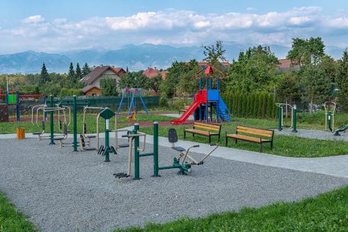 a park with a playground with benches and a slide at Apartmány Pod Chopkom in Pavčina Lehota