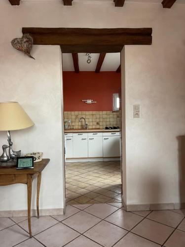 a kitchen with white cabinets and a table with a lamp at Gite Du Rittersberg in Scherwiller