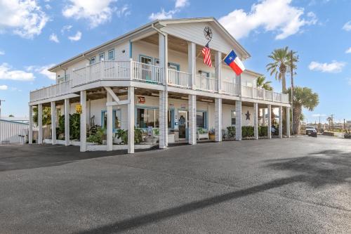 a large white building with an american flag at Tropic Island Resort in Port Aransas