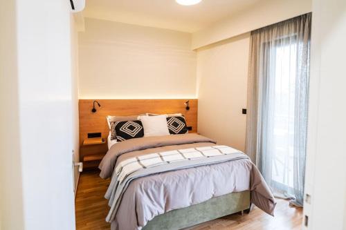 een slaapkamer met een bed en een groot raam bij AlMar- Διαμέρισμα στο κέντρο της Ηλιούπολης in Athene