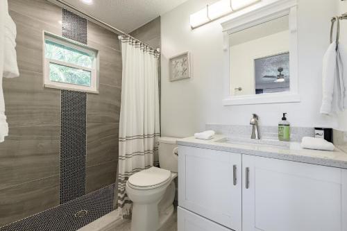 uma casa de banho branca com um WC e um chuveiro em Villa Doc Life - Roelens Vacations - Beautiful 3 bedroom, 2 bath Pool home on a gulf access canal em Cape Coral