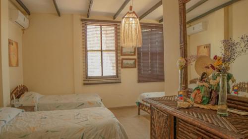 a hospital room with two beds and a mirror at Hostería Ecológica El Faro in Salinas
