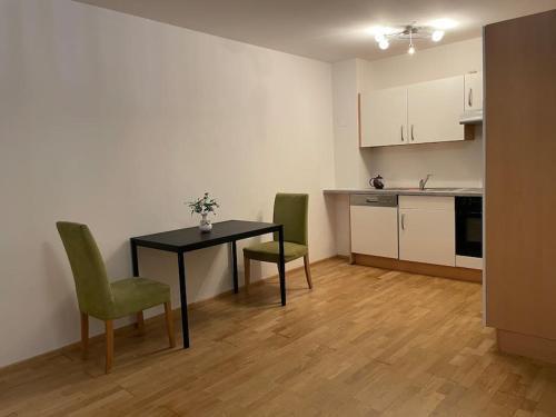 eine Küche mit einem Tisch und 2 grünen Stühlen in der Unterkunft modern and comfortable apartment next to vienna mainstation in Wien