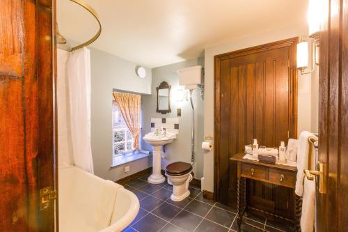 a bathroom with a tub and a toilet and a sink at Waterwheel Guesthouse in Ambleside