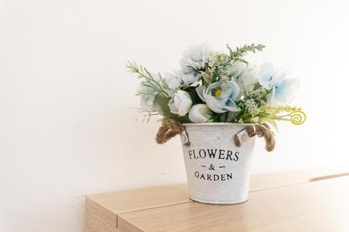 a bucket filled with flowers on a wooden shelf at PIAZZA DUOMO in Varazze