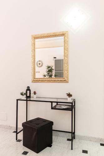 a mirror on a white wall with a black desk at PIAZZA DUOMO in Varazze