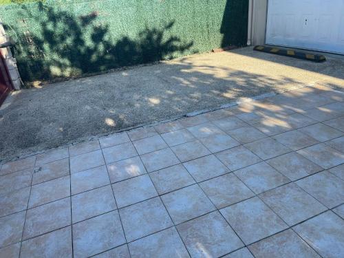 a tiled sidewalk in front of a garage at Séjour confortable et agréable pour la famille... in Étampes