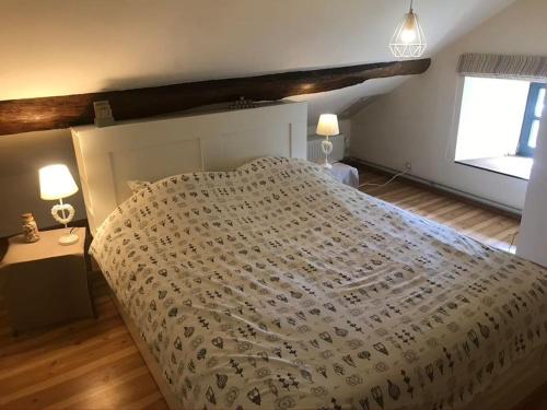 バストーニュにある1833 Ardennes farm between Bastogne and Houffalizeの大きなベッドと2つのランプがある寝室
