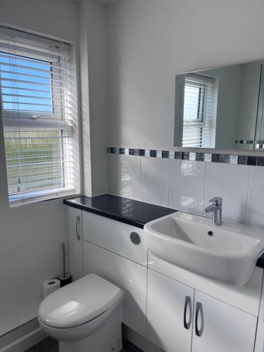 a white bathroom with a sink and a toilet at Two-bedroom Apartment in Yeovil