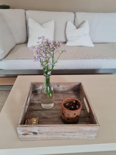 a vase with flowers on a tray on a coffee table at Ferienwohnung Unterhubers in Spabrücken