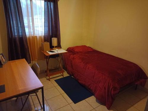 1 dormitorio con cama, mesa y ventana en Los pinos, en Tecate