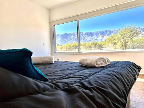 a large bed in a room with a large window at Anubis in Merlo