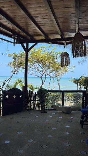 a room with a view of the ocean and a tree at Hostería Ecológica El Faro in Salinas